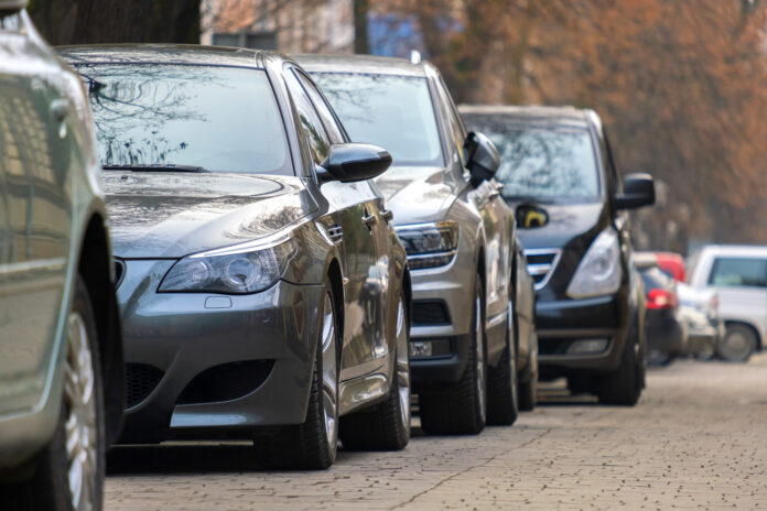 Cars parked in a row on a city street side.